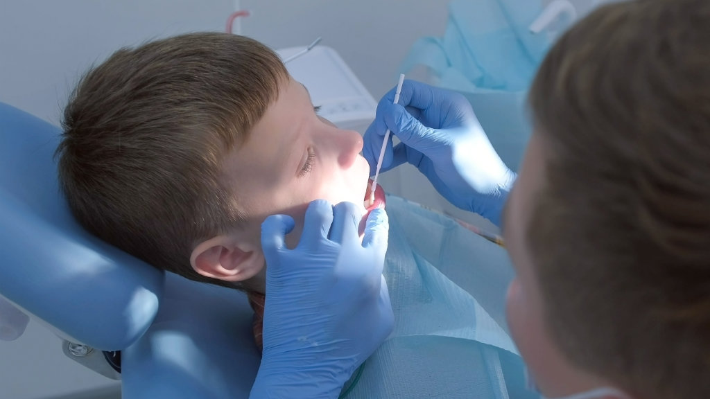 Young dental patient receiving fluoride treatment